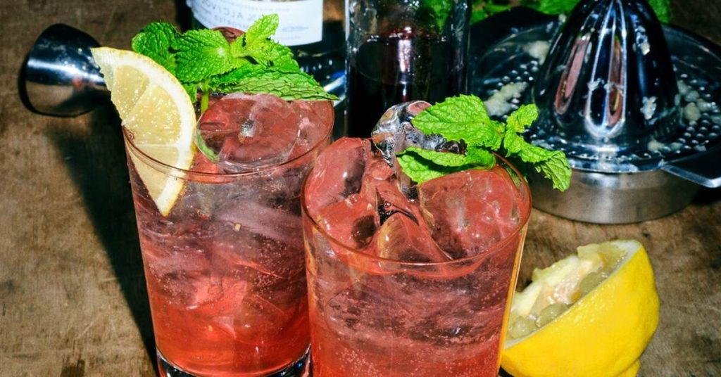 Grenadine Shake – farverig milkshake med pink og hvide nuancer, serveret i et højt glas og pyntet med sugerør og flødeskum