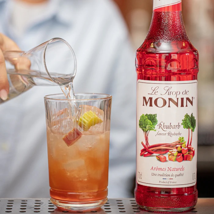 Monin rabarbersirupflaske – elegant og farverig flaske med frisk, frugtig rabarbersmag, ideel til cocktails, mocktails og desserter.
